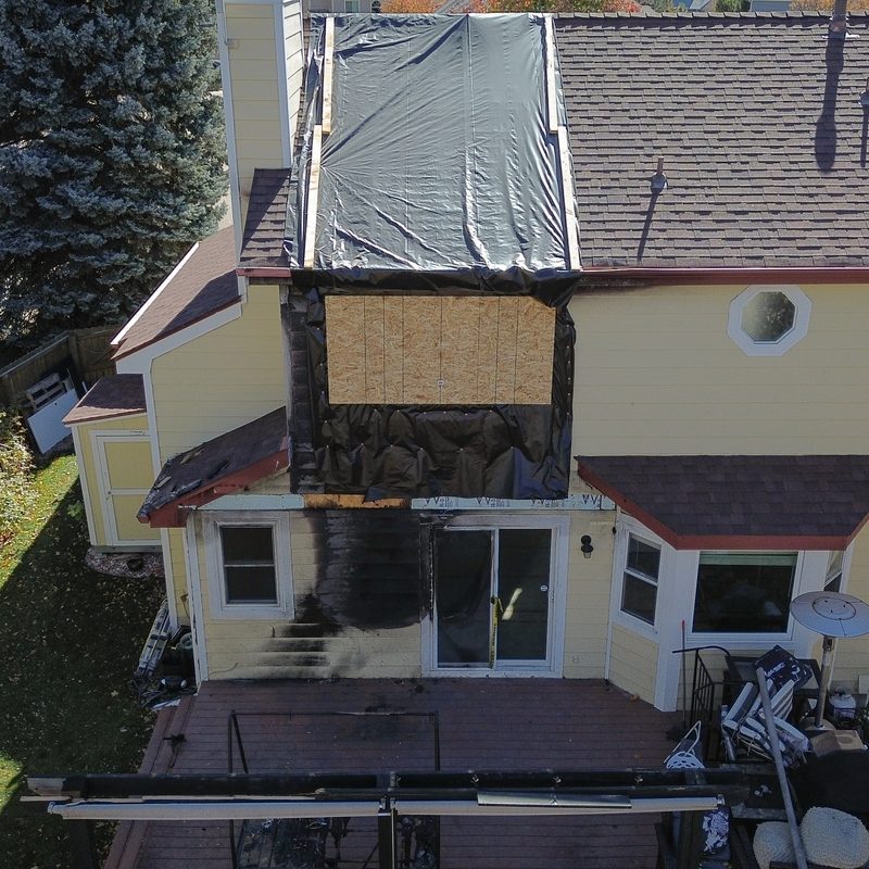 Fort Collins home after an exterior fire, with the damaged roof and siding exposed