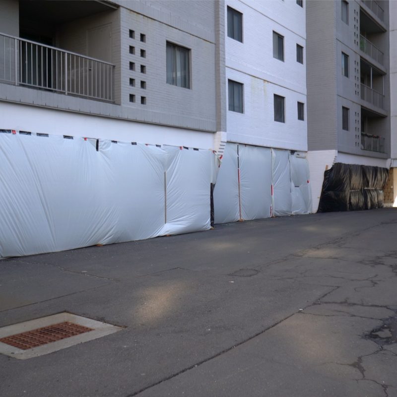 Containment sheeting run along the affected block