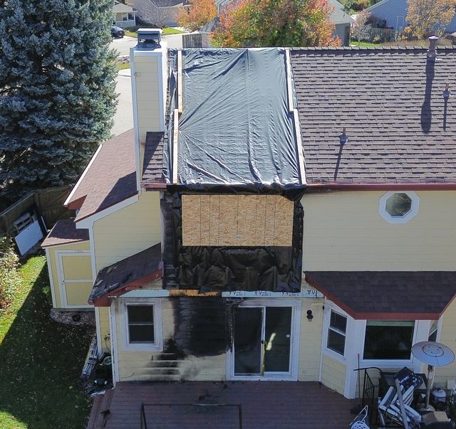 Aerial view of the fire-damaged upper storey, boarded up with the roof tarped
