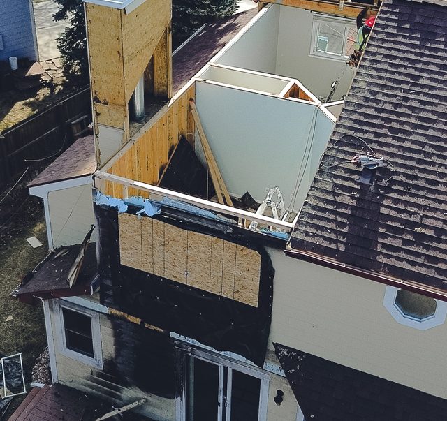 Closer aerial of the boarded opening and debris on the damaged side