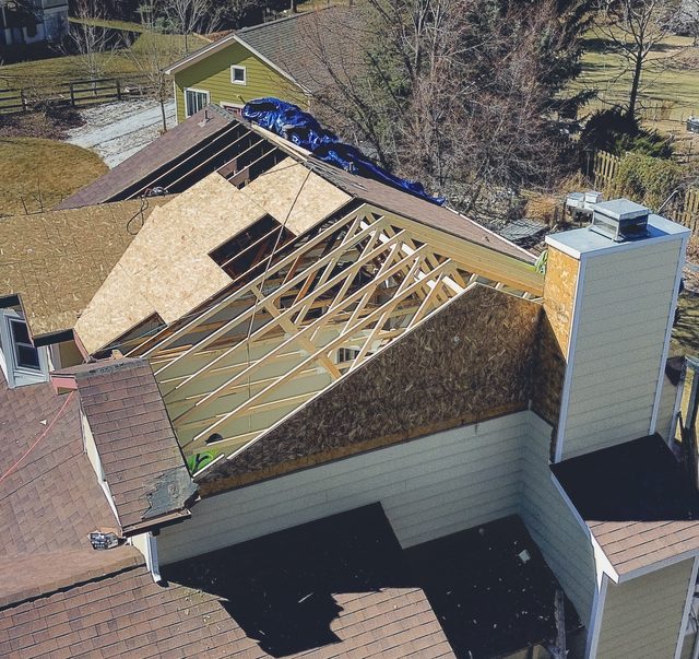 New roof trusses and sheathing set across the rebuilt section