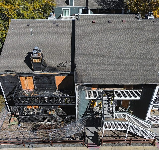Fire-damaged elevation with charred siding and burnt-out balconies