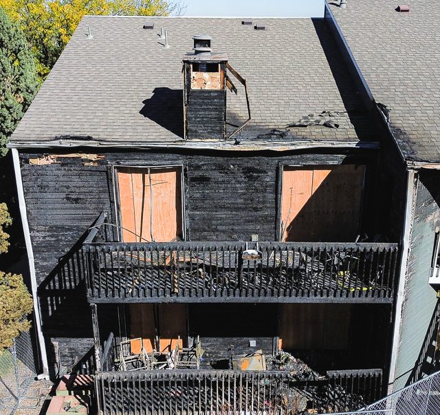 Boarded windows and scorched cladding across the upper storey