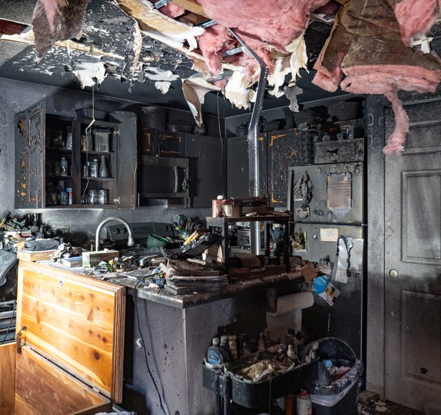 Wider view of the same gutted unit with insulation exposed