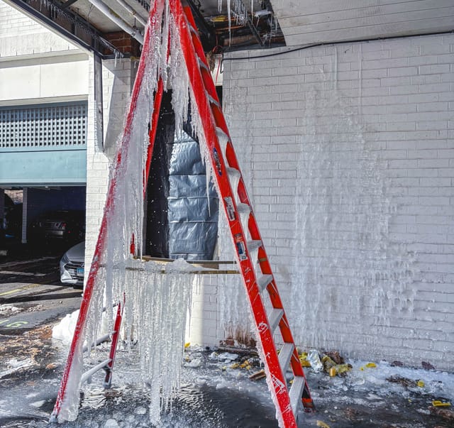 A ladder frozen solid under the burst pipe in the parking area