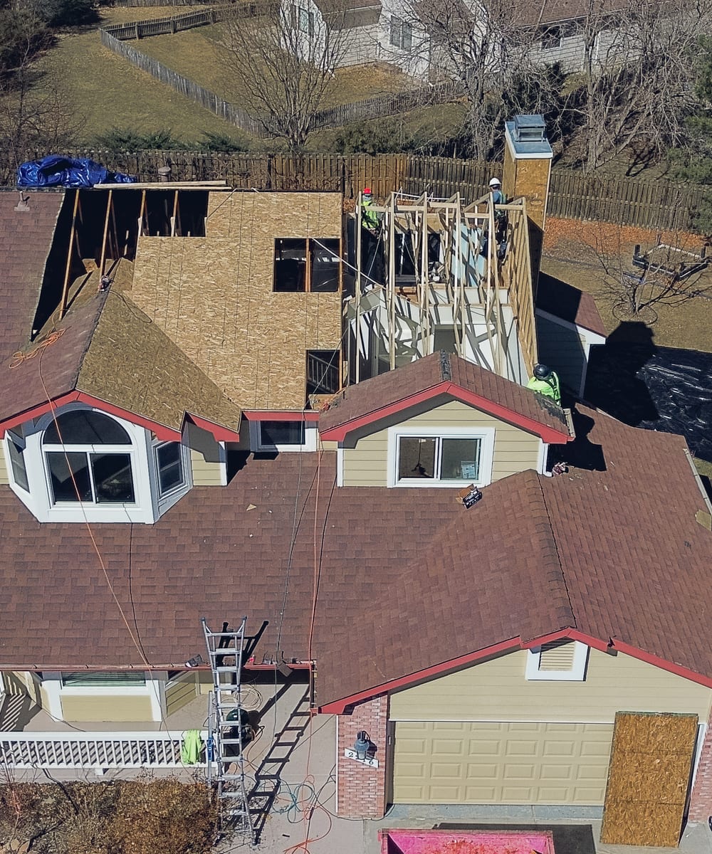 Crew reframing a house roof, seen from the air