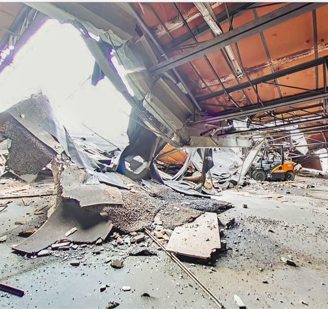 Fallen decking and structural debris beside a shored column